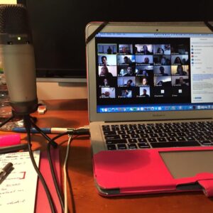 picture of computer with a group of people showing external microphone, pen and paper